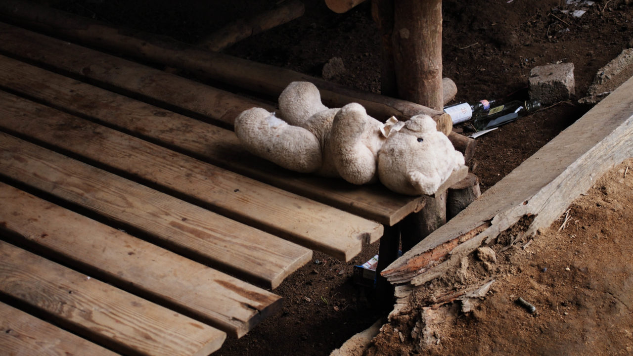 sad teddy bear on wooden plank